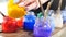 Colorful glass jars with bright paint inside. Paint brushes in jars. Many different acrylic paints in jars near to a