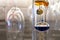 A colorful, glass, liquid filled Galileo Thermometer measures indoor room temperature in a wine cellar with wine glasses hanging