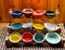 Colorful glazed bowls displayed on wooden stand