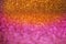 Colorful glowing golden ,orange and purple shiny glitters texture background