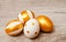 Colorful golden bright handmade painted easter eggs isolated on a wood