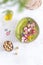 Colorful green hummus bowl with baked radish and edible flowers, vegetarian meal, top view