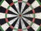 colorful grunge dartboard with red bullseye and porous caused by hard training