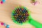 Colorful hair comb crest brushes with handle, bright beads on woden background. Mininmalistic feminine flat lay.