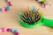 Colorful hair comb crest brushes with handle, bright beads on woden background. Mininmalistic feminine flat lay.
