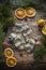 Colorful hand knitted kids socks and dried orange slices on dark wooden background