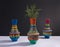 Colorful handcrafted pottery vases and green branches with harsh shadow