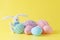 Colorful handmade easter eggs with wool clew and toy rabbit