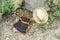 Colorful handmade wool weaving bag and straw hat on ground, Bulgaria