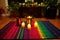 colorful handwoven kwanzaa mats with lit up kinara candles