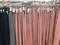 Colorful hanging woman pants on rack, earth tone color