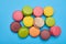 Colorful heap of macaroons isolated over blue flatlay