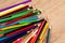 Colorful heap of pens on wooden table