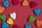Colorful heart shaped jelly candy sweets isolated on red background