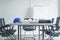 Colorful helmet and file folder on white table in meeting room.