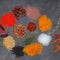 Colorful herbs and spices for cooking dishes. Indian and Asian spices On grey stone background closeup