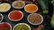 Colorful herbs and spices for cooking. Indian spices. On a black background. Top view