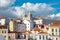 Colorful historic buildings and red tile roofs under a sky with dramatic clouds in Lisbon, Portugal