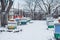 Colorful hives on apiary in winter stand in snow among snow-covered trees. Beehives in apiary covered with snow in