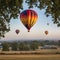 A colorful hot air balloon ascending into the early morning sky during a balloon festival.