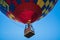 A colorful hot air balloon on a beautiful summerday with a blue sky.