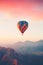 Colorful hot air balloon flying early in the morning over the mountain. Scenic sunrise or sunset view