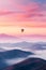 Colorful hot air balloon flying early in the morning over the mountain. Scenic sunrise or sunset view