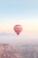 Colorful hot air balloon flying early in the morning over the mountain. Scenic sunrise or sunset view