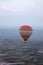 Colorful Hot Air Balloon Flying In Foggy Sky Above Fields
