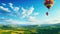 a colorful hot air balloon gracefully floating over a picturesque field with a radiant blue sky as the backdrop. The