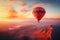 Colorful hot air balloon over desert mountains at sunset