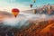 A colorful hot air balloon soaring over a great nature landscape represents an exhilarating adventure