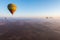 Colorful hot air balloons floating above the vast Moroccan desert expanse