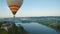 Colorful hot air balloons fly over the medieval castle and lake in the morning fog. Maneuverable flight. Travel