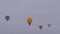 Colorful hot air balloons flying against grey winter sky at aerostat festival