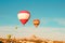 Colorful hot air balloons flying near Uchisar castle at sunrise, Cappadocia, Turkey