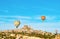 Colorful hot air balloons flying near Uchisar castle at sunrise, Cappadocia, Turkey