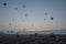 Colorful hot air balloons flying over the valley and rock formations with fairy chimneys. Cappadocia, Turkey