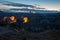 Colorful hot air balloons glowing in early morning dawn while filling up with hot air. Mountain landscape in Cappadocia