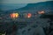 Colorful hot air balloons glowing while filling up with hot air. Mountain landscape in blue hour sunrise