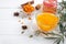 Colorful hot natural sea buckthorn tea in a glass cup, fresh raw berries and leaves, honey, anise and cinnamon sticks. Vitaminic