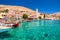 Colorful houses and fishing boats in picturesque small island Halki Chalki in Greece