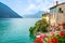 Colorful houses and flowers of Gandria village and scenic view of Lake Lugano on summer day in Switzerland