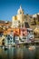 Colorful houses and an old church in Corricella village on Procida island, Italy
