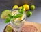 Colorful image of glass of lemonade or gin tonic with lemons and lime