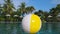 Colorful inflatable beach ball floating in swimming pool