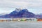 Colorful Inuit buildings in residential district of Nuuk city with lake in the foreground and snow peak of Sermitsiaq mountain,