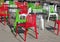Colorful italian themed outdoor cafe chairs and tables on the street in summer sunlight in red green and white colors