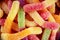 Colorful jelly marmalade worms, sweet delicious background. Light sweet dessert. Macro photo.