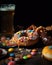 Colorful junk food snacks like chips, donuts, and candy laid out on a table with a cold beer bottle